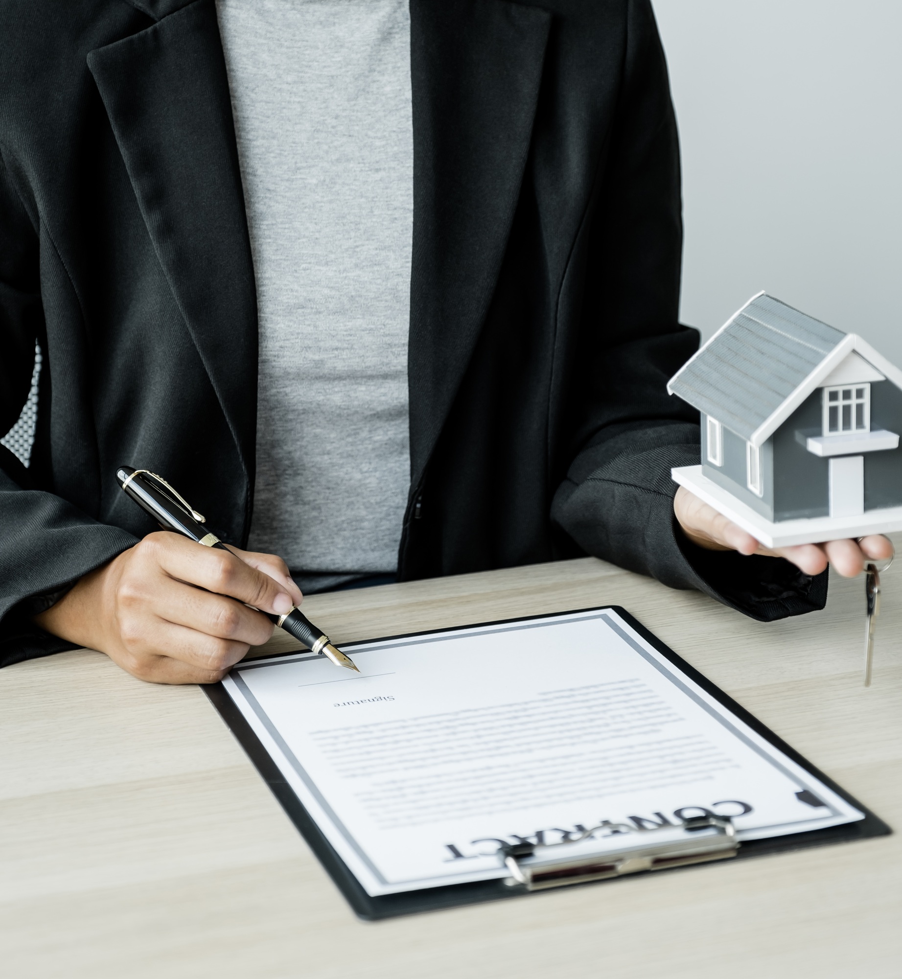 Hand a real estate agent sign with home model, key and explain the business contract